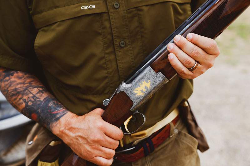 Close-up of a sportsman holding an engraved over-under shotgun — hunting lifestyle session
